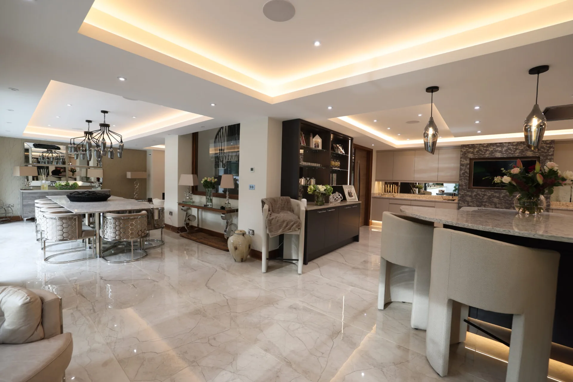 Open-plan kitchen and dining space with marble flooring and coffered ceiling lighting